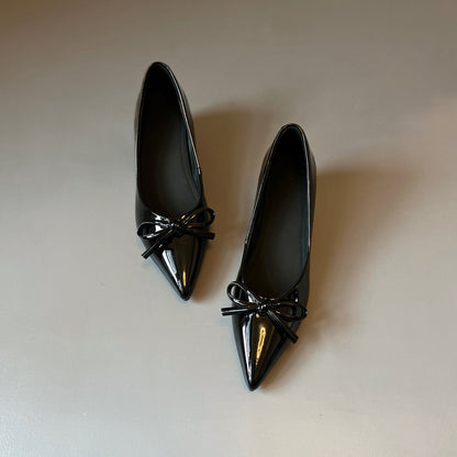 Zapatos de charol con elevación interna que estilizan la figura