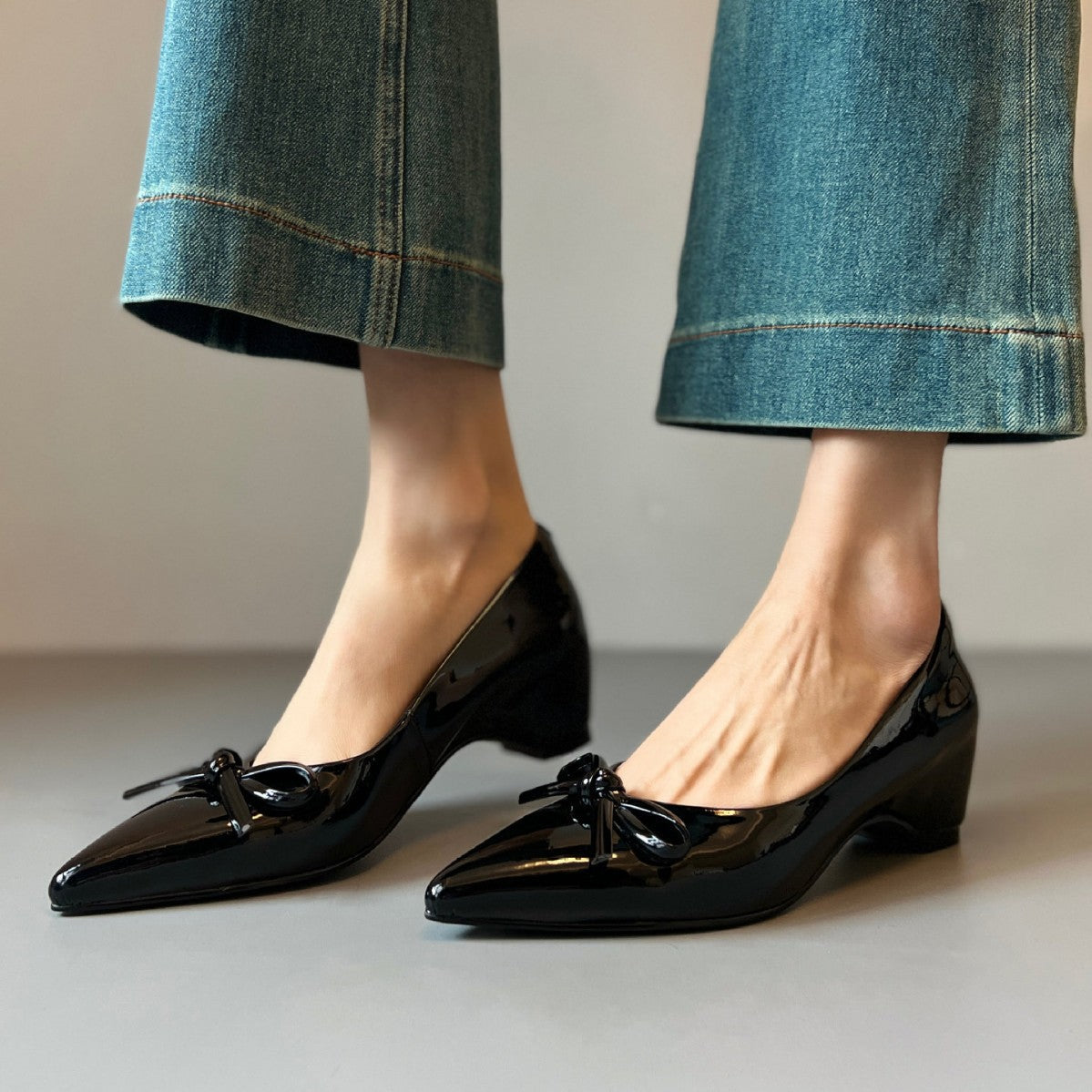 Zapatos de charol con elevación interna que estilizan la figura